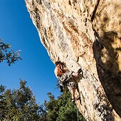 Een klimmer zorgt voor een goede backup bij het beklimmen van een rots