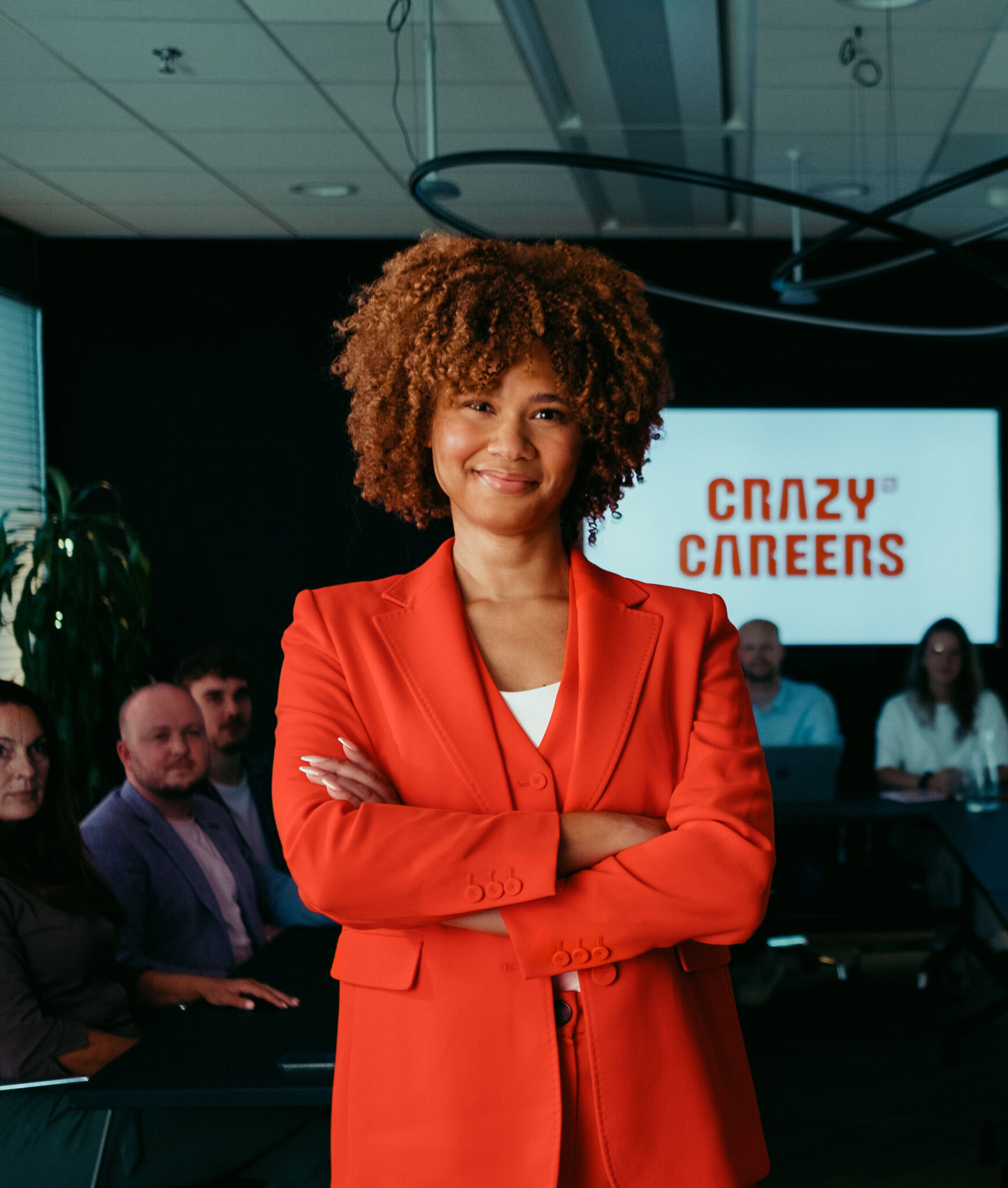 Innovatieve digitale marketingstrategie expert vrouw in conferentiezaal met collega’s, gericht op bedrijfsontwikkeling, online groei, en digitale transformatie, onder titel Crazy Careers.