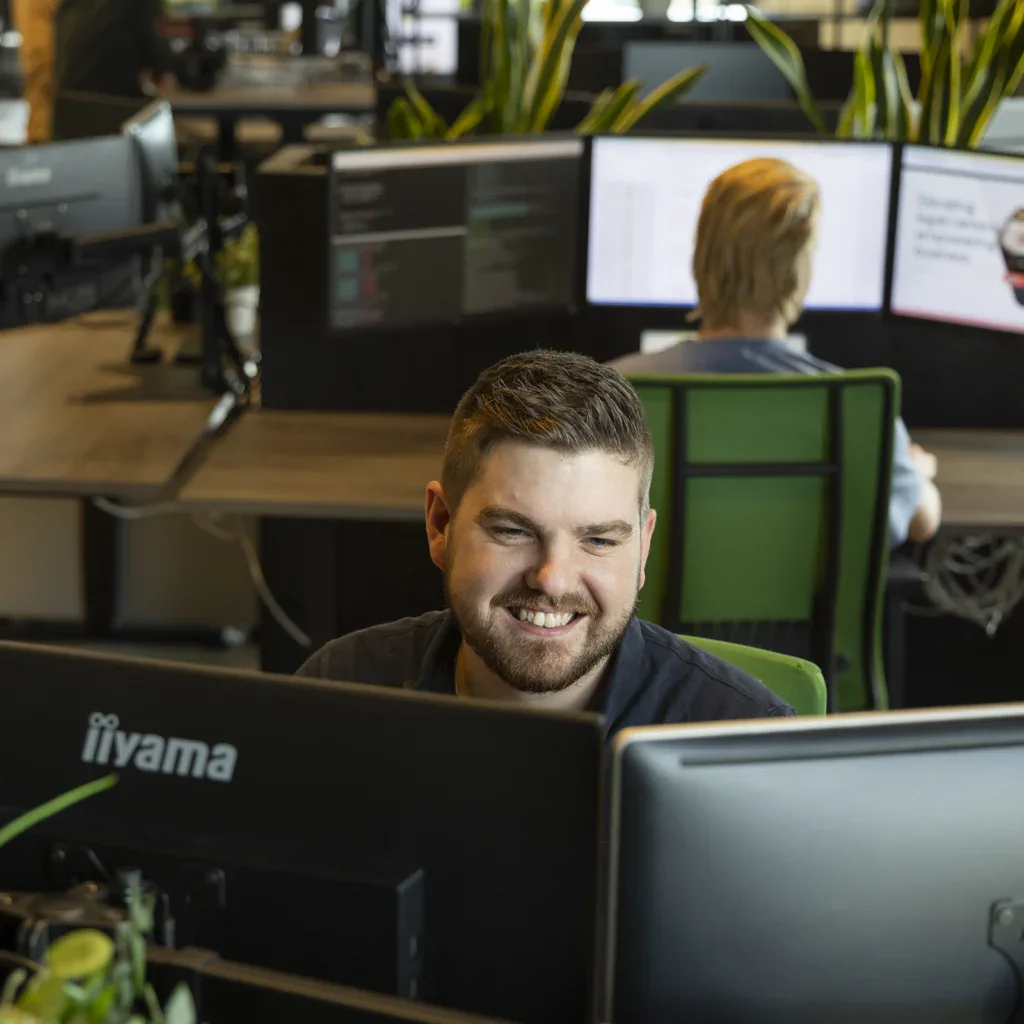 Een WordPress specialist heeft plezier in zijn werk terwijl hij maatwerk code in WordPress schrijft.