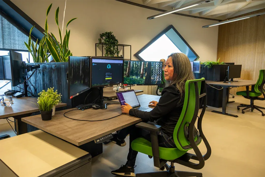 Een project manager zit achter haar computer en is een het werk op kantoor.