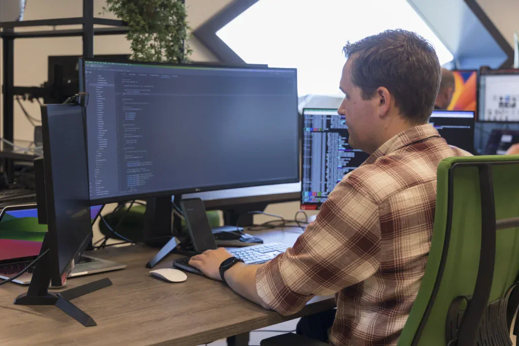 Back end developer is aan het werk achter zijn bureau.