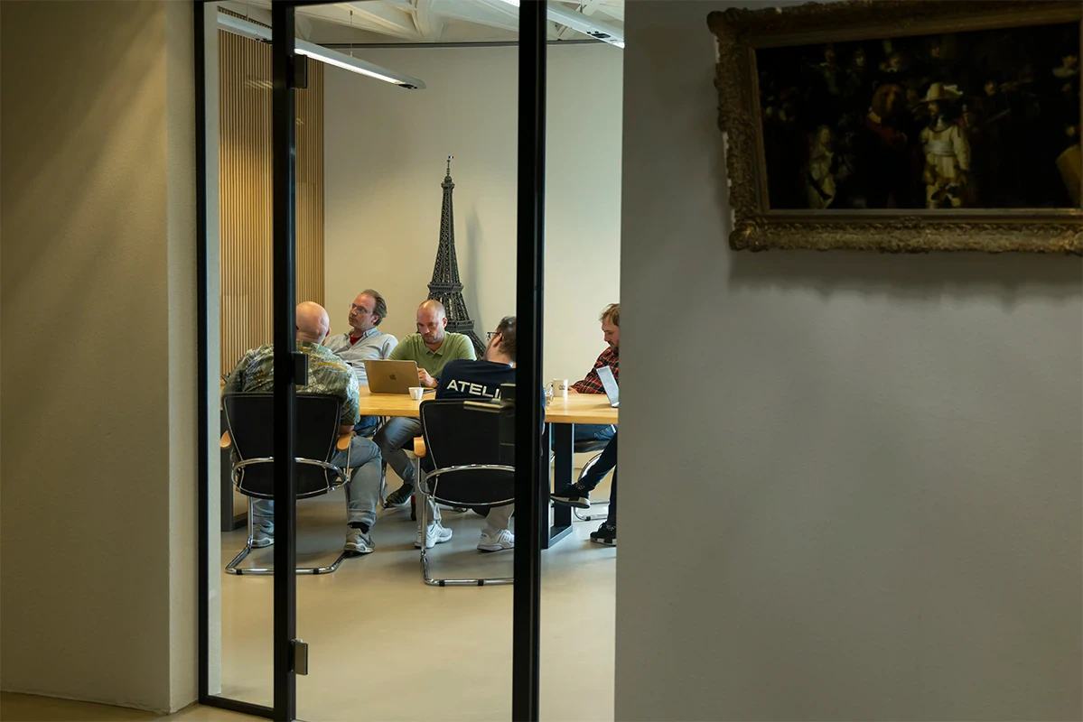Het team aan tafel in de vergaderkamer tijdens een overleg.