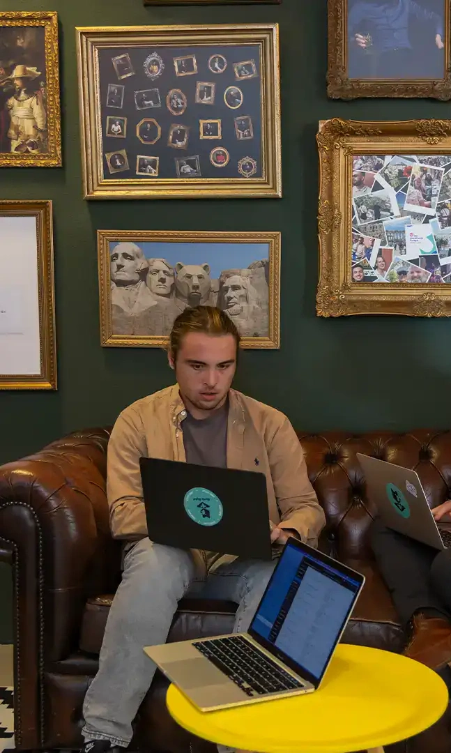 Twee collega's zijn aan het overleggen en zitten op een leren bank.