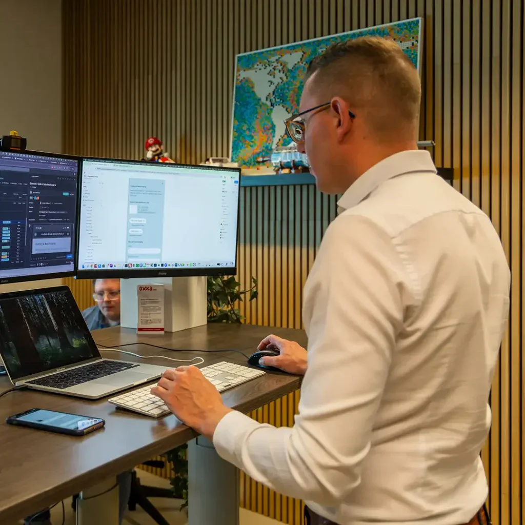 Collega is staand aan het werk achter zijn laptop.