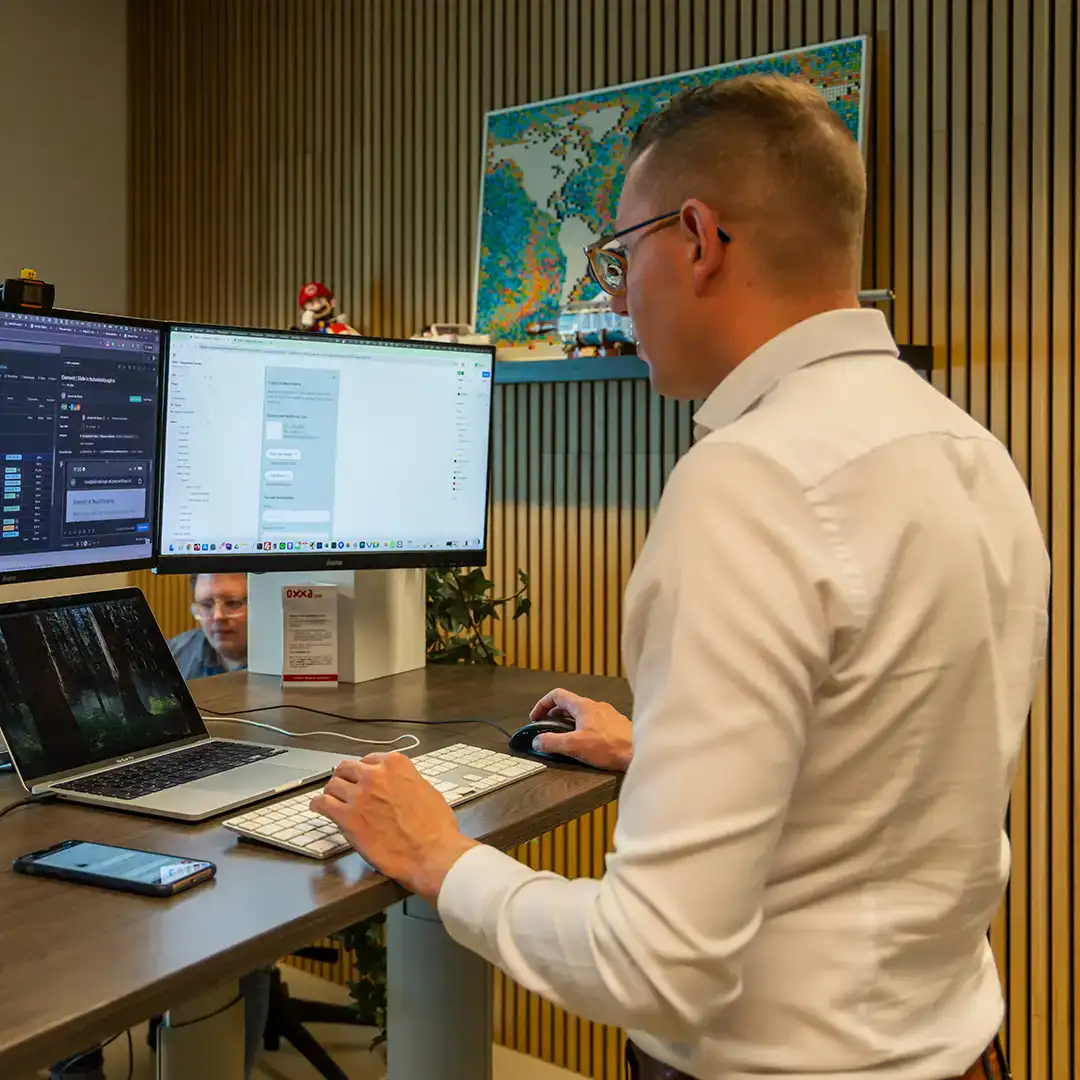 Collega is staand aan het werk achter zijn laptop.