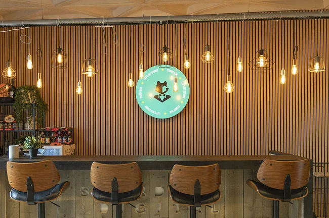 Een houten bar met daarboven lichtjes een lichtbak met het Sturdy logo.