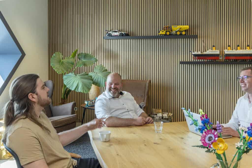 Innovatief team in modern kantoor, creatieve ontmoeting, digitale marketing, strategiebesprekingen, werkplek met planten en modelbouw, professionele werkomgeving, teamwork, communicatie, bedrijfscultuur, Sturdy Digital.