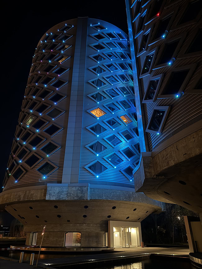 Moderne hoogbouw met opvallende blauwe LED-verlichting, archivabiliteit en ontwerp voor digitale bedrijfsintegratie, perfect voor SEO door focus op innovatieve architectuur en technologie.